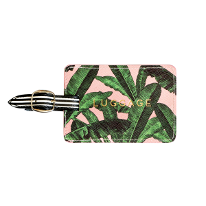 Alice Scott Luggage Tag. Adorned with a pink and banana leaf design it features the word 'Luggage' in gld foil detailing. The luggage tag also has a buckle detail used to attach to your suitcase